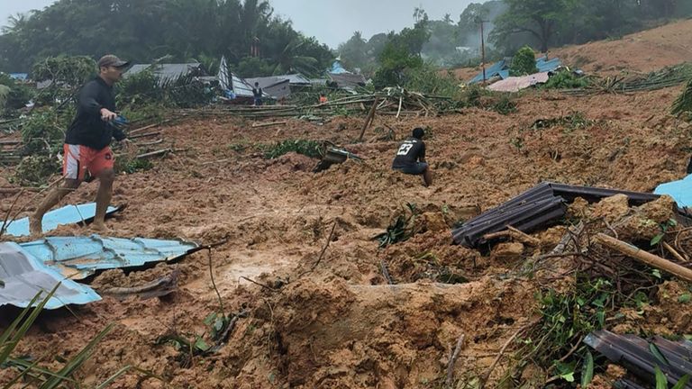In this frame grab made from video released by Indonesia&#39;s National Disaster Management Agency (BNPB), people inpspect the site where a landslide hit a village on Serasan Island, Natuna regency, Indonesia, on Monday, March 6, 2023. The landslide caused by torrential rain killed a number of people and left dozens of others missing on the remote island, disaster officials said. (BNPB via AP)