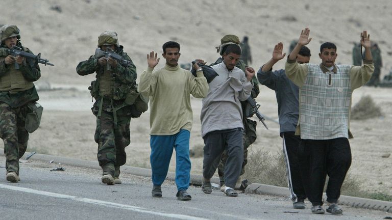US military escort a group of Iraqi soldiers dressed in civilian clothes north of Basra, Iraq, in 2003