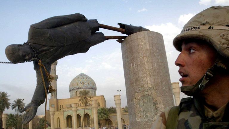 FILE PHOTO: U.S. Marine Corp Assaultman Kirk Dalrymple watches as a statue of Iraq&#39;s President Saddam Hussein falls in central Baghdad&#39;s Firdaus Square, in this file photo from April 9, 2003. A powerful blast ripped through the Mount Lebanon Hotel March 17, 2004 which is located behind Firdaus Square. The war started on March 20 Baghdad local time, March 19 Washington D.C. local time. REUTERS/Goran Tomasevic/File Photo