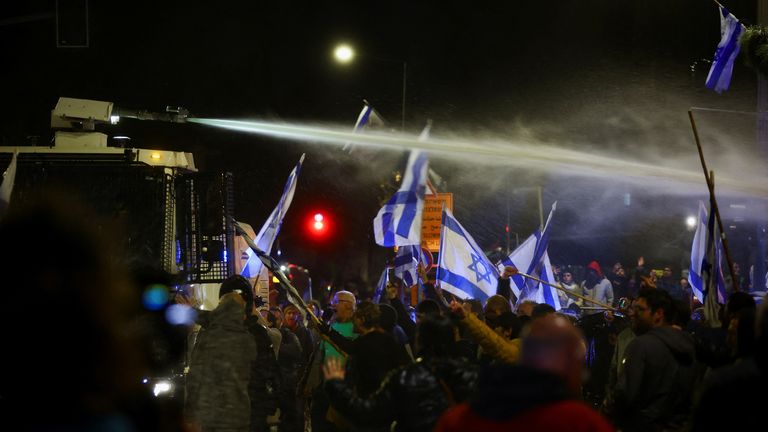 A water cannon is used as people attend a demonstration after Israeli Prime Minister Benjamin Netanyahu dismissed the defense minister and his nationalist coalition government presses on with its judicial overhaul, in Jerusalem, March 26, 2023. REUTERS/Ronen Zvulun