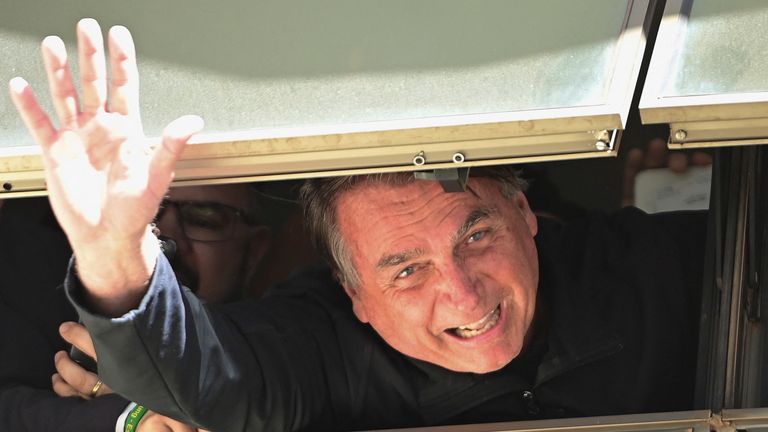 Jair Bolsonaro waves at Brasilia International Airport as he returns from self imposed exile in Florida