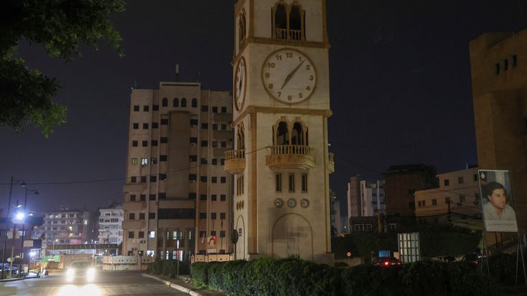 A car drives near a clock tower in Jdeideh, Lebanon