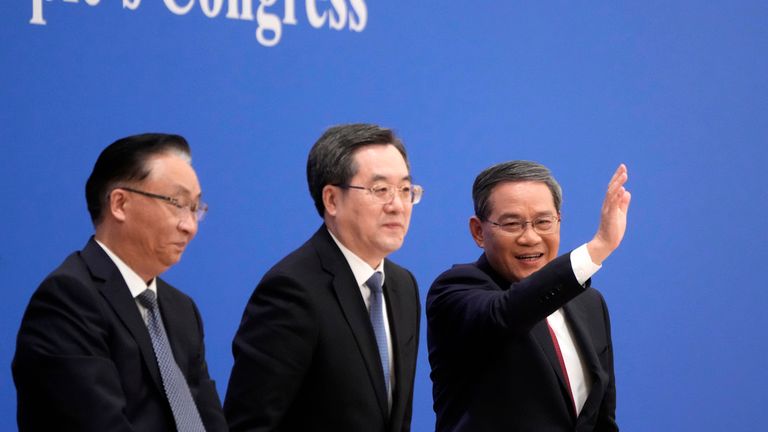 Chinese Premier Li Qiang, waves beside Chinese Vice Premiers, as he walks past Chinese Vice Premiers Zhang Guoqing, left, and Ding Xuexiang, center at the end of a press conference held after The closing ceremony for the National People of China's Congress (NPC) at the Great Hall of the People in Beijing, Monday, March 13, 2023. (AP Photo/Mark Schiefelbein)