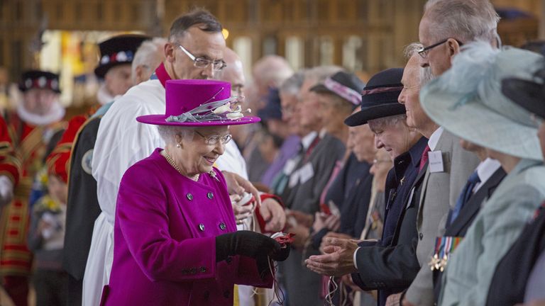 Queen Elizabeth II foreground left, reacts with pensioners, during the Maundy Thursday service, at Blackburn Cathedral, in Blackburn, England, Thursday, April 17, 2014. 