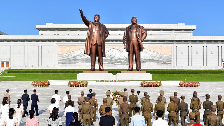 İnsanlar, Kuzey Kore'nin başkentindeki Mansu Tepesi'nde merhum Kuzey Kore liderleri Kim Il Sung ve Kim Jong Il'in heykellerinin önüne çiçek bıraktı.
