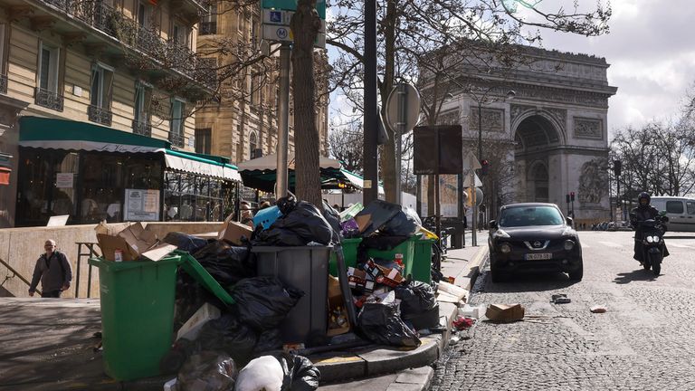 Uncollected garbages are pictured near the Arc de Triomphe in Paris, Tuesday, March 14, 2023. The City of Light is losing its luster with tons of garbage piling up on Paris sidewalks as sanitation workers strike for a ninth day. (AP Photo/Thomas Padilla)