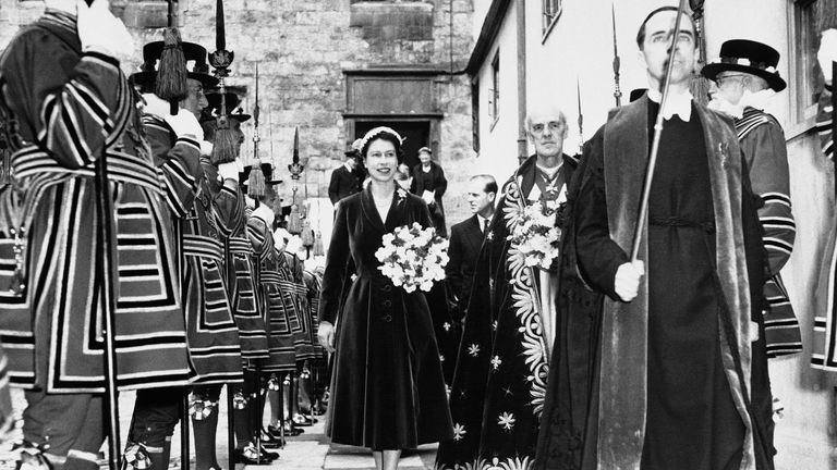 Queen Elizabeth II walks past honor guard of yeoman warders from the Tower of London after carrying out the annual service of distributing the  Maundy money in 1956