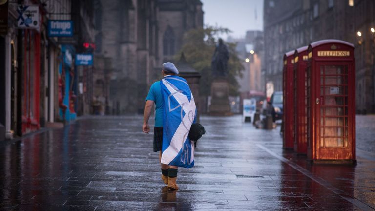 A dejected &#39;Yes&#39; supporter in Edinburgh makes his way home in the early hours after Scotland voted decisively to reject independence and remain part of the Union.