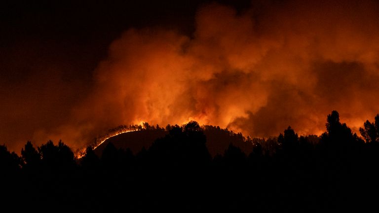 A forest fire burns in the hills near Villanueva de Viver, Spain, in the early hours of Friday