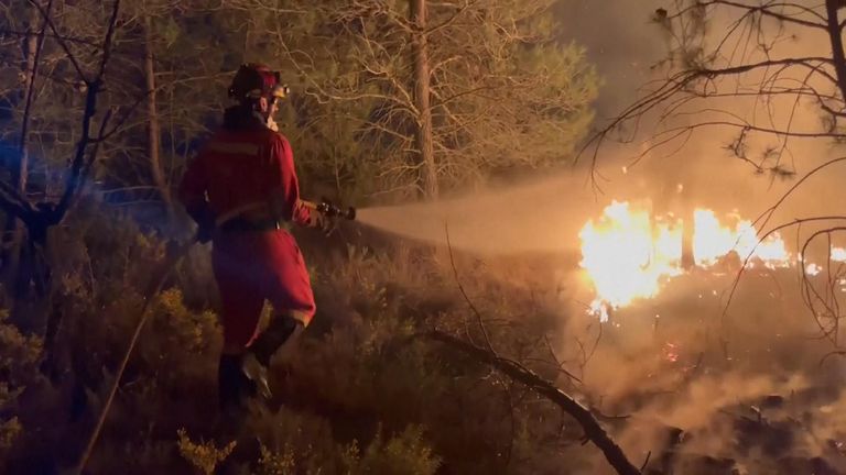 İtfaiyeci İspanya'da bir ormanda çıkan yangını hortumla söndürdü