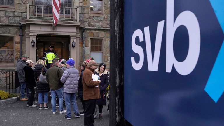 Bir kolluk görevlisi, Pazartesi günü ABD'deki bir SVB şubesinin önündeki kuyrukları izliyor.  Resim: AP