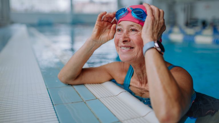 woman leaning on edge of swimming pool