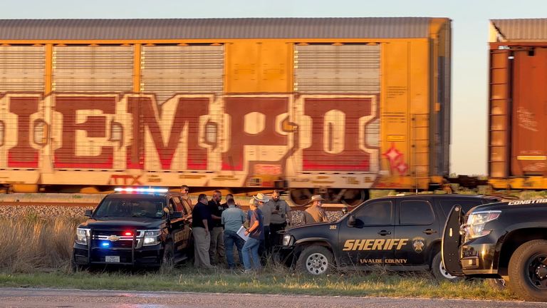 Members of the police work, after two migrants suffocated to death aboard a freight train that got derailed, in Uvalde, Texas