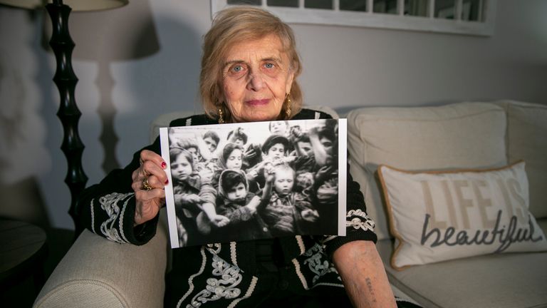 Tova Friedman showing the number the Nazis tattooed on her left arm. She is on the left in the black and white photo, aged six. Pic: AP