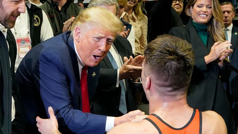 Former President Donald J. Trump, left, congratulates Princeton wrestler Pat Glory, right, after winning the NCAA wrestling title in the 125-pound class Saturday, March 18, 2023 in Tulsa, Oklahoma.  (AP Photo/Suo Grokey)