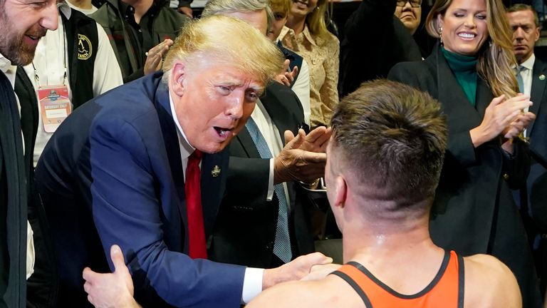 Former President Donald J. Trump, left congratulates Princeton wrestler Pat Glory, right, after Glory won the NCAA Wrestling Championship at the 125 lb class, Saturday, March 18, 2023, in Tulsa, Okla. (AP Photo/Sue Ogrocki)