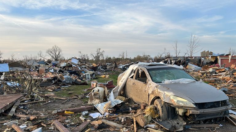 A car next to blown away homes after deadly tornado 