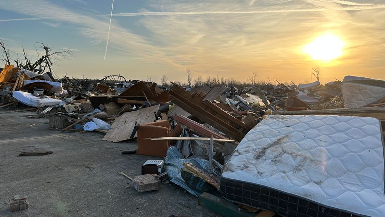 A mattress lays bare among broken buildings and home appliances after a deadly tornado struck 