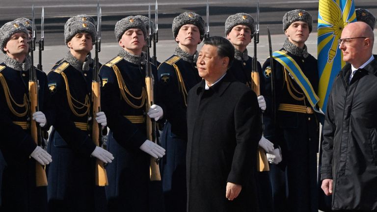 Chinese President Xi Jinping, accompanied by Russian Deputy Prime Minister Dmitry Chernyshenko, walks past honour guards and members of a military band during a welcoming ceremony upon his arrival at an airport in Moscow, Russia, March 20, 2023. Kommersant Photo/Anatoliy Zhdanov via REUTERS RUSSIA OUT. NO COMMERCIAL OR EDITORIAL SALES IN RUSSIA.