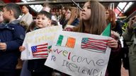 Families of US embassy staff hold placards as President Joe Biden arrives at Dublin International Airport