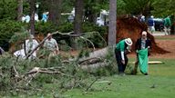 Grounds staff collect debris on the fairway after a tree is uprooted on the 17th hole as inclement weather conditions cause play to be suspended for the second time during the second round
