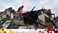 A volunteer inspects remains of a residential house damaged by a Russian missile strike, amid Russia's attack on Ukraine, in Zaporizhzhia