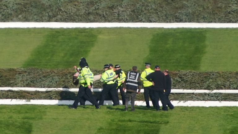 Police officers respond to Animal Rising activists attempting to invade the race course