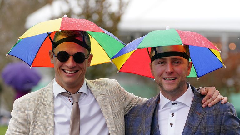 Racegoers shelter under umbrella hats ahead of the the Air Charter Service Mildmay Novices&#39; Chase during day two of the Randox Grand National Festival at Aintree Racecourse, Liverpool. Picture date: Friday April 14, 2023.