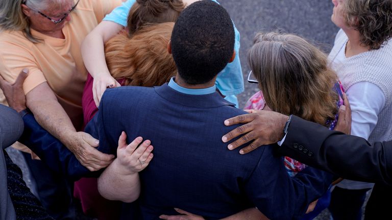 Community members embrace each other during a vigil the day after a shooting during a teenager's birthday party at Mahogany Masterpiece Dance Studio in Dadeville, Alabama 
