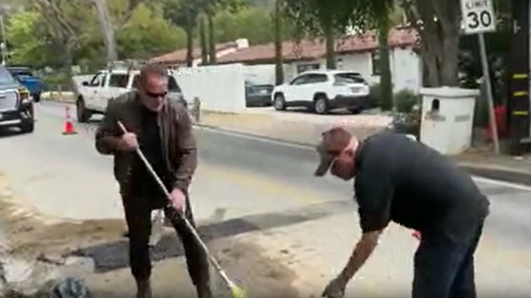 Arnold Schwarzenegger fills a pothole in his neighbourhood in California.