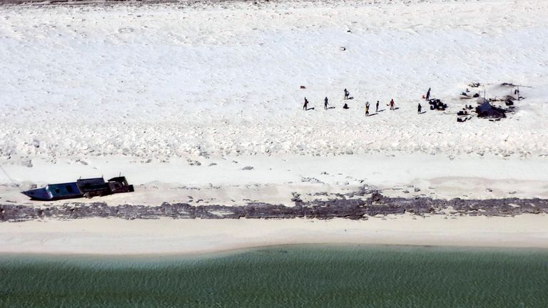 In this photo provided by the Australian Maritime Safety Authority, fishermen from Indonesia stand on a beach on Bedwell Island, 313 km (194 miles) west of Broome, Australia (Australian Maritime Safety Authority via AP)