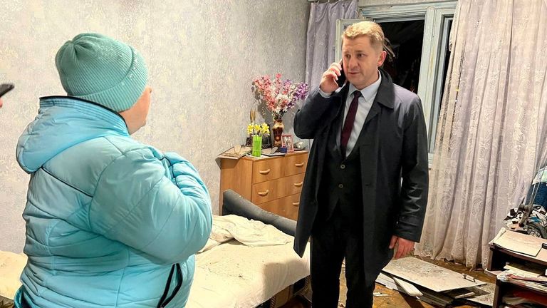 Mayor of the city of Belgorod Valentin Demidov speaks with a local resident in a damaged apartment