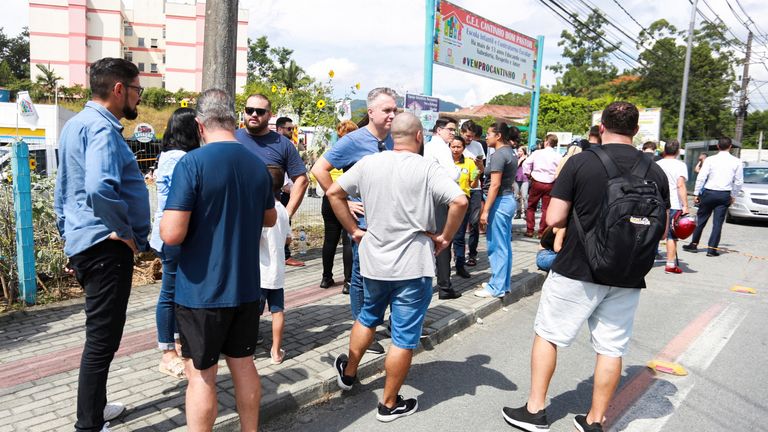 Employees and relatives stand outside a pre-school after a 25-year-old man attacked children, killing several and injuring others, according to local police and hospital, in Blumenau, in the southern Brazilian state of Santa Catarina, Brazil April 5, 2023. REUTERS/Denner Ovidio NO RESALES. NO ARCHIVES