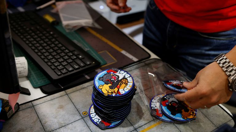 Alec Hsu puts patches depicting a Formosan black bear holding Taiwan’s flag and punching Winnie the Pooh, inside individual plastic bags at his store in Taoyuan, Taiwan April 10, 2023. REUTERS/Carlos Garcia Rawlins
