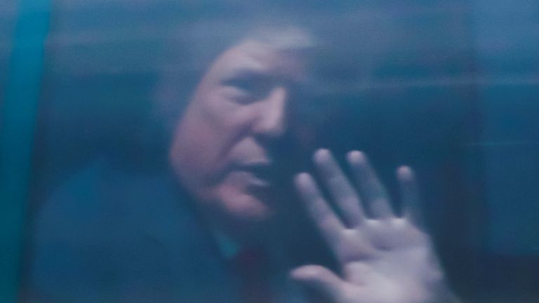 Donald Trump waves from a motorcade as he arrives at Palm Beach international airport in Florida.