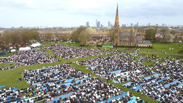 Muslim worshippers gathering to pray together, marking the end of the fasting month of Ramadan and the beginning of Eid al-Fitr at Platt Fields Park in Manchester,