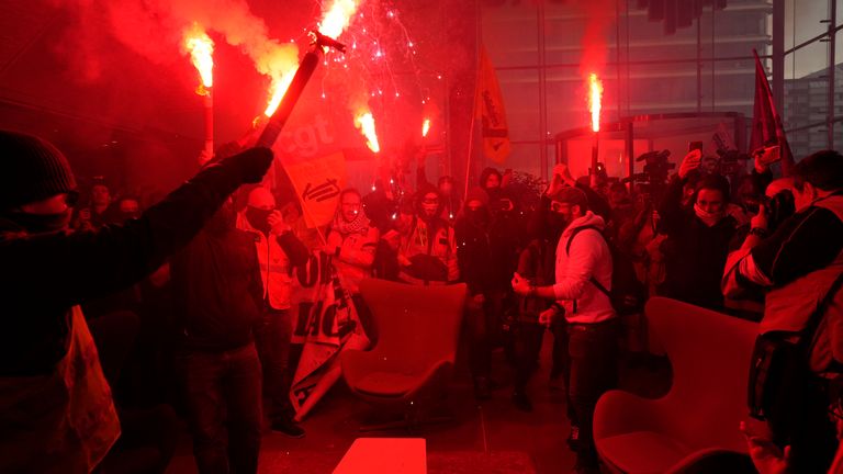 Demonstrators holding flares invading the Euronext Paris building in protest  at the pension reforms
Pic:AP