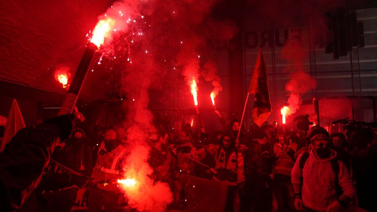 Demonstrators holding flares inside the Euronext Paris building in protest to the pension reforms 
Pic:AP
