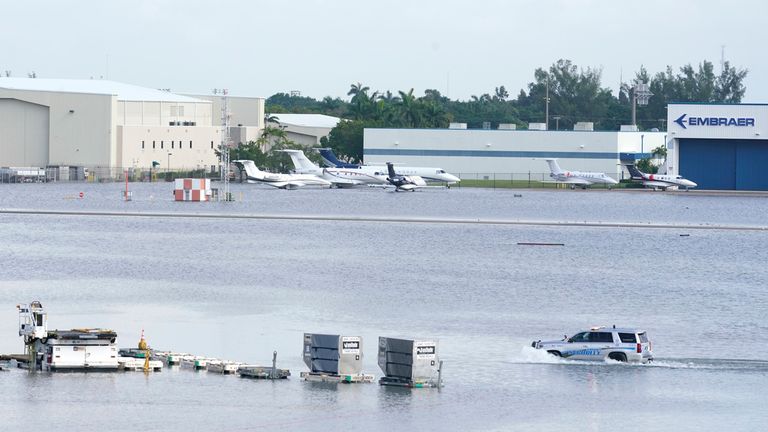 A truck drives on the flooded runway at Fort Lauderdale- Hollywood International Airport, Thursday, April 13, 2023, in Fort Lauderdale, Fla. Fort Lauderdale issued a state of emergency as flood conditions continued through many areas. Over 25 inches of rain fell in South Florida since Monday causing widespread flooding.(AP Photo/Marta Lavandier)