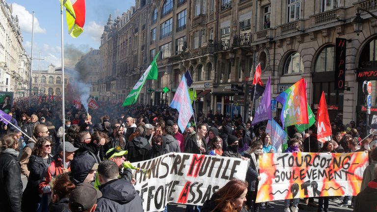 Protestocular, 13 Nisan 2023 Perşembe günü Fransa'nın kuzeyindeki Lille'de bir gösteri sırasında yürüyor.  Cumhurbaşkanı Emmanuel Macron'un Fransa'da emeklilik yaşını yükseltmeye yönelik pek rağbet görmeyen planına karşı çıkan protestocular, tedbirin anayasal standartları karşılayıp karşılamadığına ilişkin bir karar verilmeden önce Perşembe günü Fransa'nın dört bir yanındaki şehir ve kasabalarda son bir öfke gösterisi için yürüdüler.  (AP Fotoğrafı/Michel Spingler)