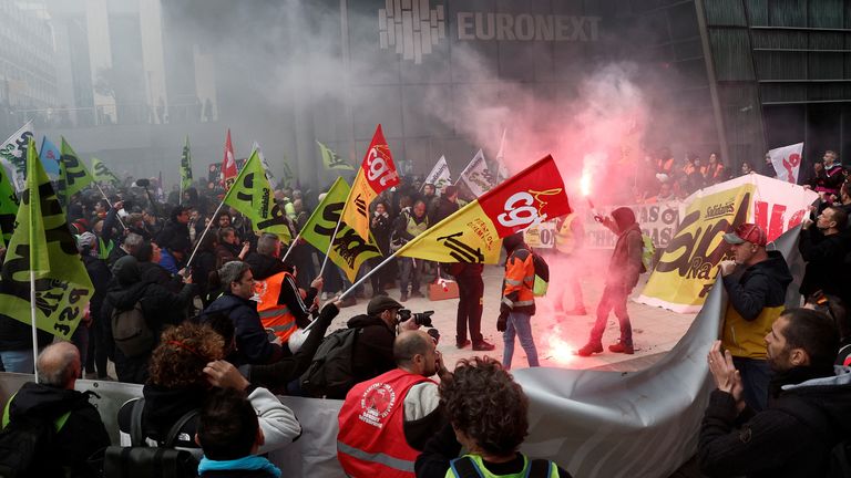 French SNCF railway workers on strike, holding red flares and CGT and Sud Rail labour unions flags, gather in front of the headquarters of stock market operator Euronext at La Defense business and financial district as part of a "day of expression of railway anger" following months of strikes and a failed attempt to halt pension reforms, in Courbevoie near Paris, France, April 20, 2023. REUTERS/Benoit Tessier
