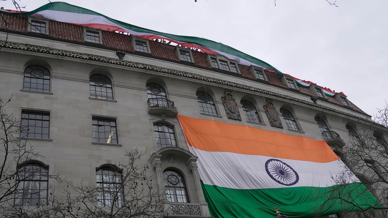 Khalistan hareketinin protestocuları 22 Mart 2023 Çarşamba Londra sokaklarında gösteri yaparken insanlar Hindistan Yüksek Komisyonu'nun çatısından bir Hint bayrağı gösteriyor.(AP Fotoğrafı/Kin Cheung)