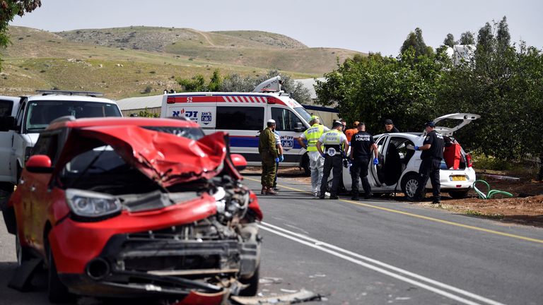 Israeli medics and policemen check a damaged car at the scene of a shooting  in the Jordan Valley in the Israeli-occupied West Bank 