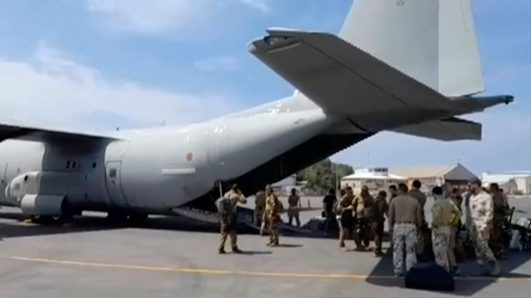 In this image provided by the Italian Defence Ministry, military personnel evacuate people from the airport in Khartoum