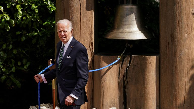 U.S. President Joe Biden rings the Peace Bell, during a meeting with Irish President Michael Higgins, at Aras an Uachtarain, in Dublin, Ireland, April 13, 2023. REUTERS/Kevin Lamarque

