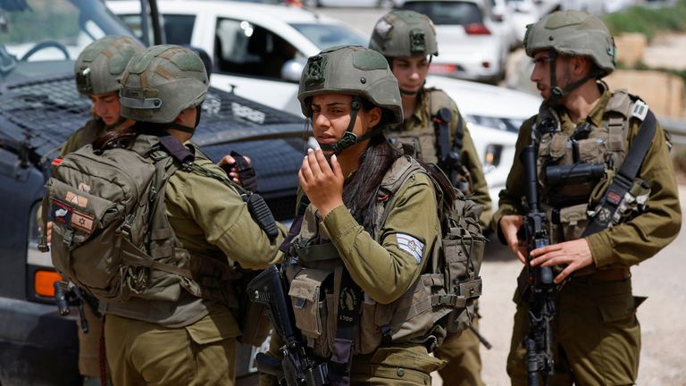 Israeli troops stand guard where a shooting took place  in the Jordan Valley in the Israeli-occupied West Bank  