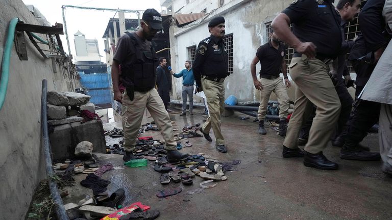 Polis memurları, 31 Mart 2023 Cuma günü Pakistan'ın Karaçi kentinde izdiham alanını inceliyor. Pakistan'ın güneyindeki liman kenti Karaçi'deki bir fabrikanın önünde bir Ramazan gıda dağıtım merkezinde meydana gelen ölümcül izdihamda çok sayıda kişi öldü, polis, polis ve kurtarma görevlileri söyledi.  (AP Fotoğrafı/Fareed Khan)