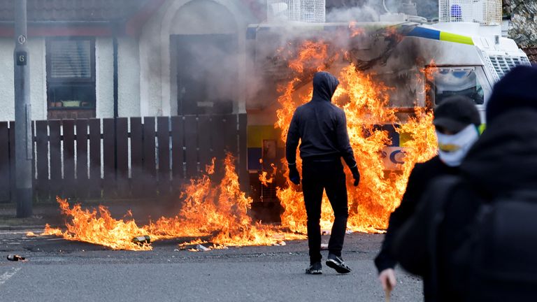 Members of nationalist group Dissident Republicans stand near a burning police car as nationalists hold an anti-agreement rally on the 25th anniversary of the peace deal, in Londonderry, Northern Ireland, April 10, 2023. REUTERS/Clodagh Kilcoyne
