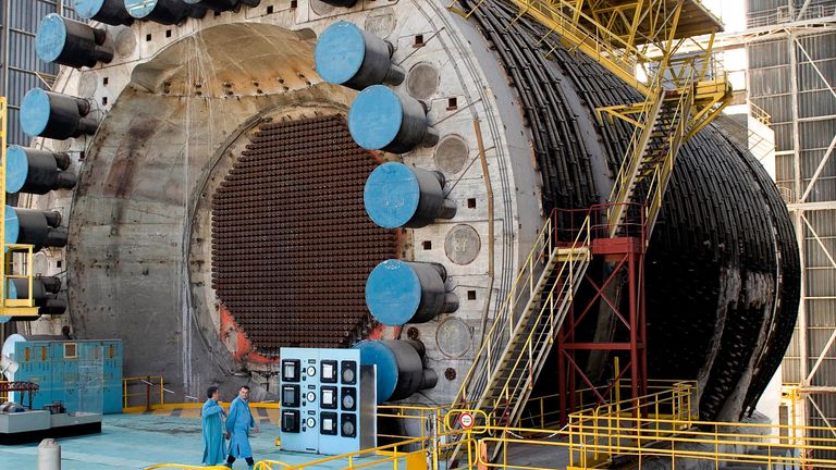 Two employees walk past a G2 reactor at the French nuclear Marcoule site in southeastern France