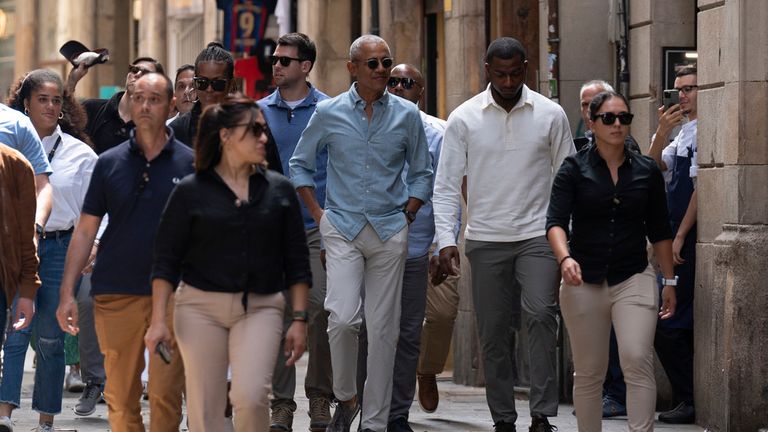 The Obamas walk through central Barcelona. Pic: AP